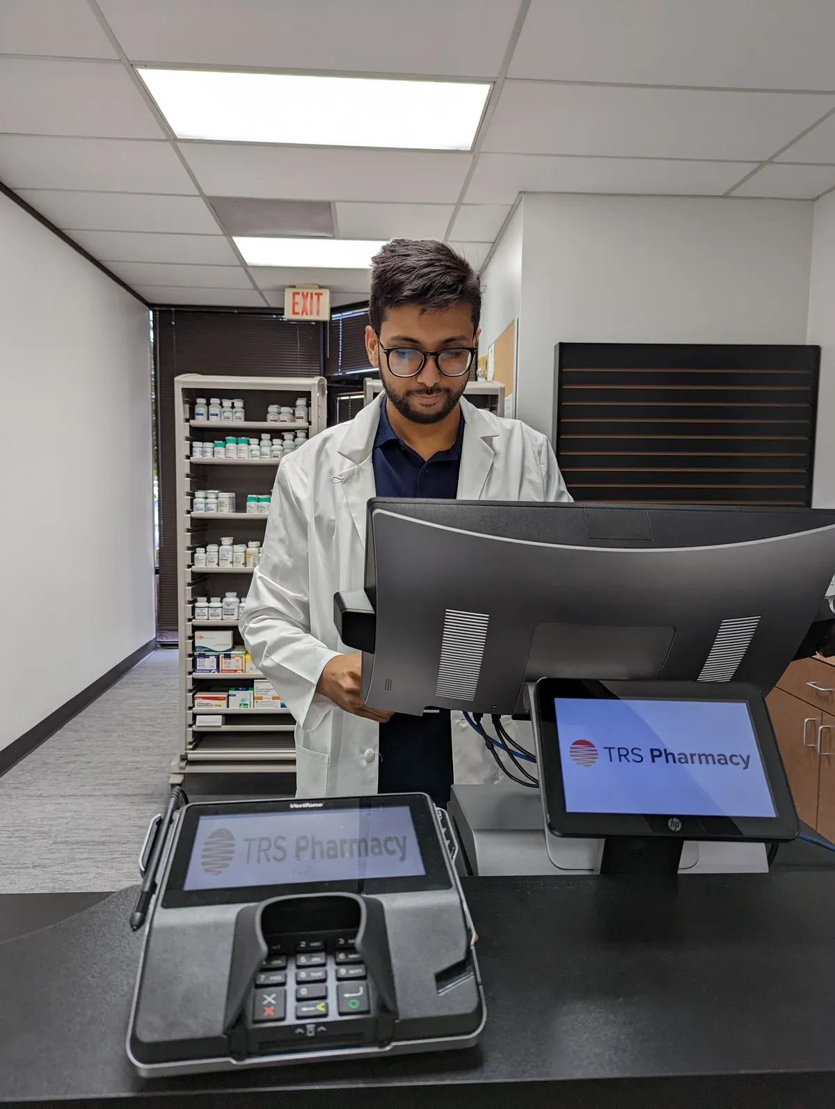 Haroon Waseem, PharmD, at the TRS Pharmacy dispensing counter in Stafford, TX